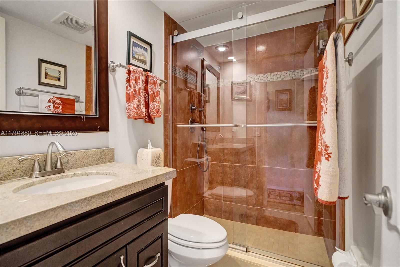 3520 Oaks Way, Unit 308 Pompano Beach, FL 33069 - Photo 15 of 40 a bathroom with a sink a toilet a mirror and shower