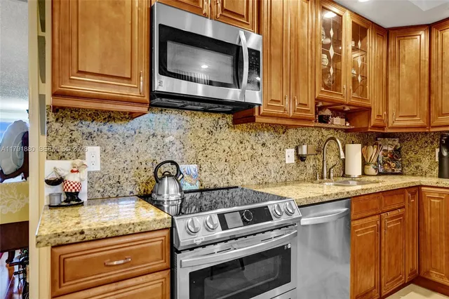 a kitchen with granite countertop cabinets stainless steel appliances and a sink
