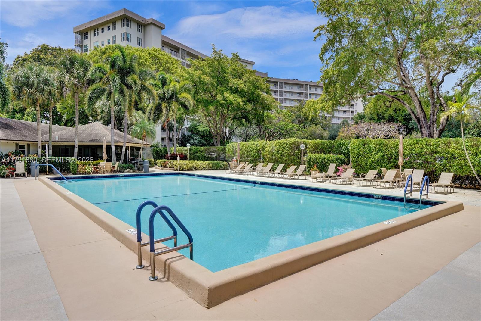 3520 Oaks Way, Unit 308 Pompano Beach, FL 33069 - Photo 31 of 40 a view of a swimming pool with a patio and a garden