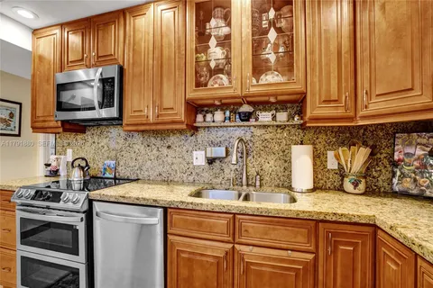 a kitchen with stainless steel appliances granite countertop a sink a stove and a microwave