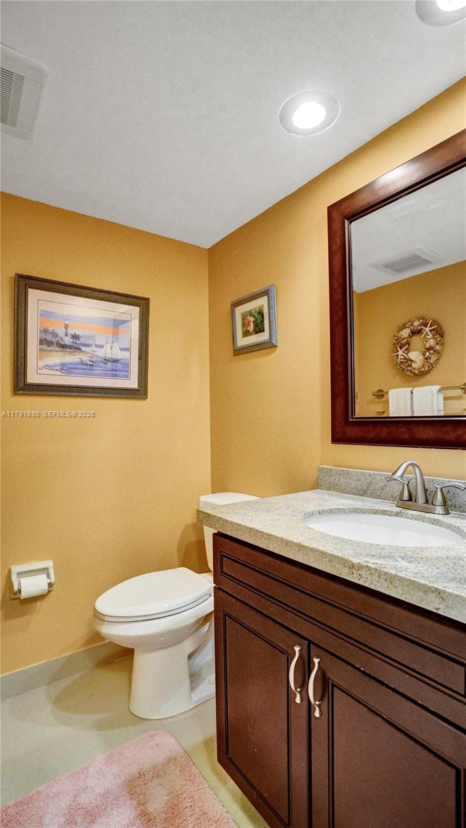 3520 Oaks Way, Unit 308 Pompano Beach, FL 33069 - Photo 5 of 40 a bathroom with a sink a toilet and mirror