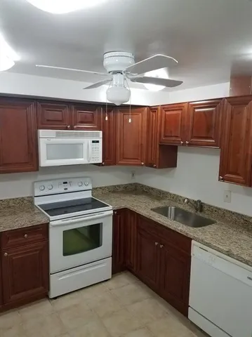 a kitchen with granite countertop a sink and a stove