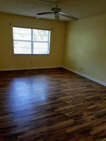 a view of a room with wooden floor and a window