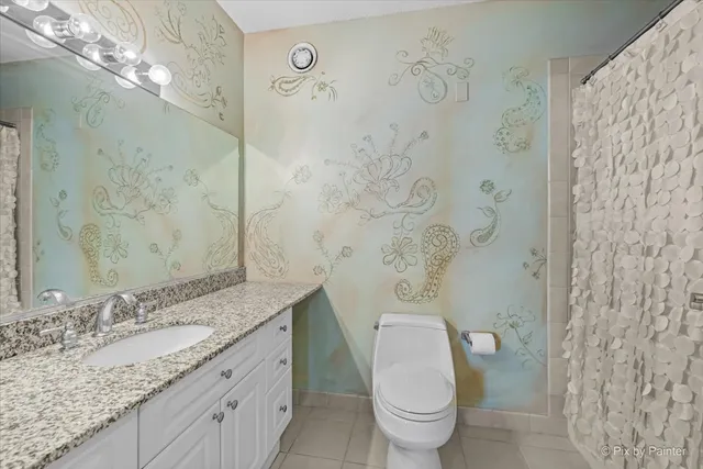 a bathroom with a granite countertop sink a toilet and a shower