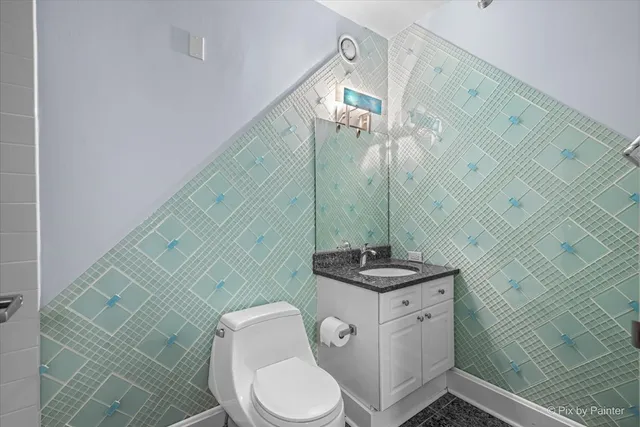 a bathroom with a granite countertop toilet sink and mirror