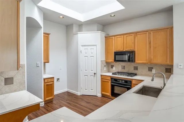 a kitchen with stainless steel appliances a stove a sink a microwave and cabinets