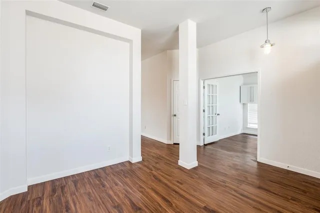 an empty room with wooden floor and a window
