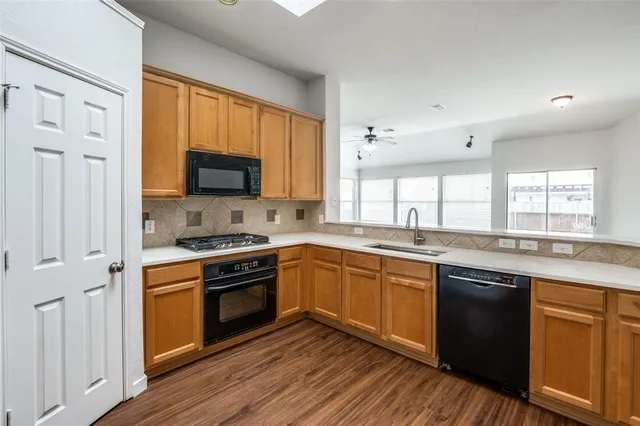 a kitchen with stainless steel appliances granite countertop wooden floor sink stove and granite counter top