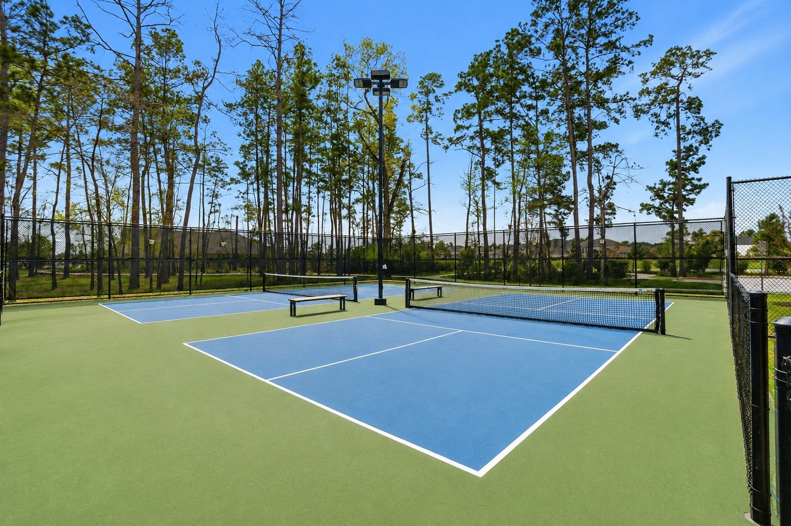 4022 Sabine Valley Trail Spring, TX 77386 - Photo 42 of 46 Beautiful community tennis courts featuring a clean playing surface, surrounding fencing, and mature trees for a scenic outdoor setting. A wonderful neighborhood amenity for recreation, fitness, and enjoying time outdoors.