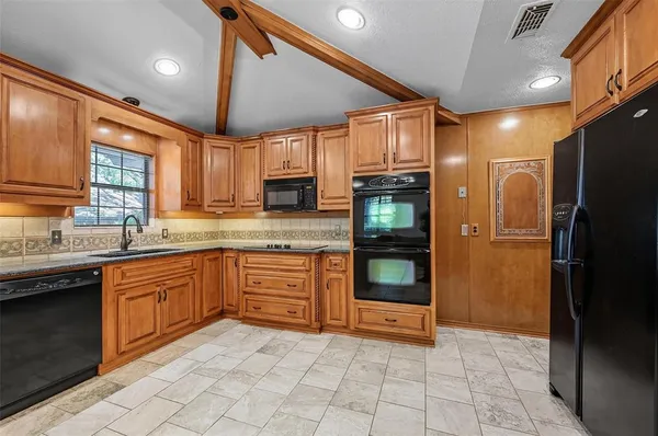 a kitchen with stainless steel appliances granite countertop a refrigerator and a sink
