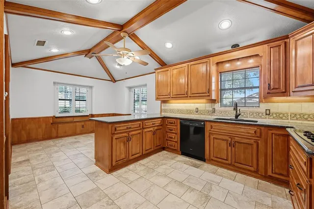 a large kitchen with stainless steel appliances granite countertop a sink and cabinets