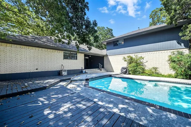 a view of backyard with swimming pool and outdoor seating