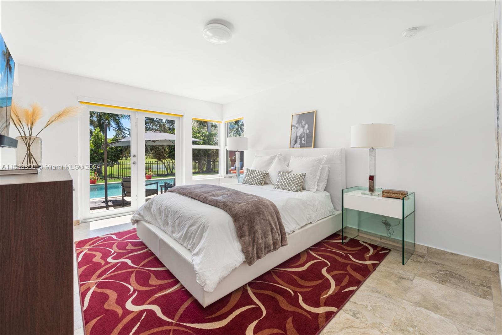 5301 Alton Road Miami Beach, FL 33140 - Photo 19 of 28 a bedroom with a bed and a lamp next to a window
