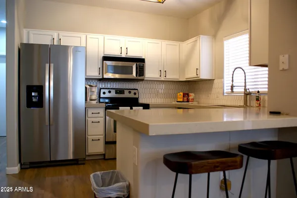 a kitchen with stainless steel appliances a refrigerator a sink a stove and cabinets