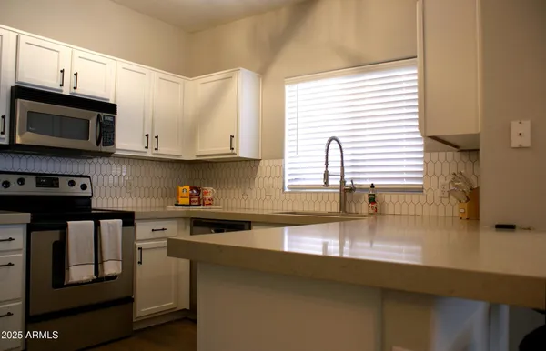 a kitchen with stainless steel appliances granite countertop a sink a stove and microwave