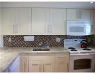 2311 South Cypress Bend Drive, Unit 416 Pompano Beach, FL 33069 - Photo 4 of 16 a kitchen with a stove and cabinets