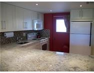 2311 South Cypress Bend Drive, Unit 416 Pompano Beach, FL 33069 - Photo 5 of 16 a kitchen with a refrigerator and cabinets