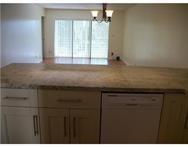 2311 South Cypress Bend Drive, Unit 416 Pompano Beach, FL 33069 - Photo 6 of 16 a kitchen with a sink a window and cabinets