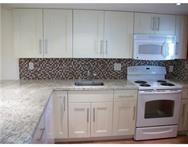 2311 South Cypress Bend Drive, Unit 416 Pompano Beach, FL 33069 - Photo 7 of 16 a kitchen with a stove and cabinets