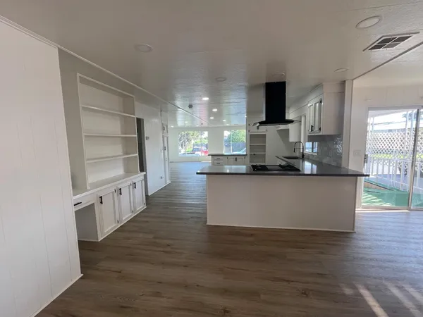 a view of kitchen with kitchen island stainless steel appliances counter top space and living room