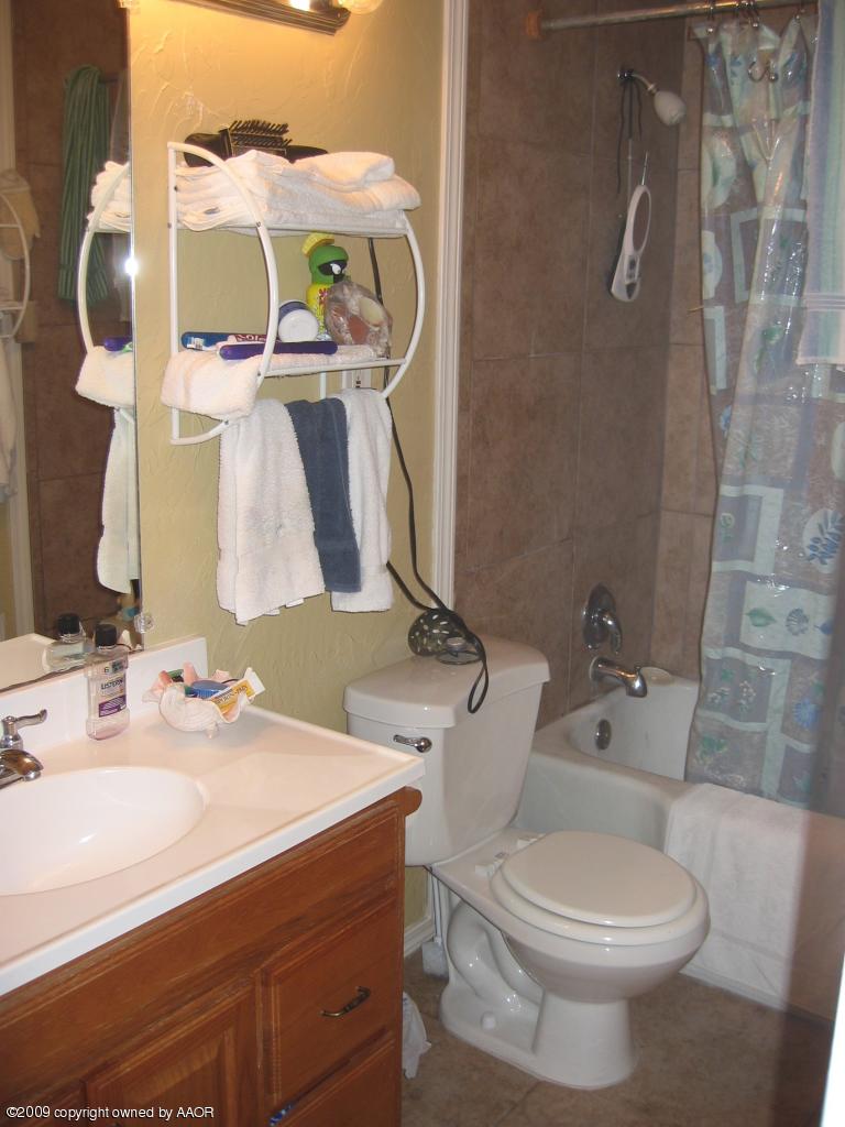 3625 South Hayden Street Amarillo, TX 79110 - Photo 6 of 6 a bathroom with a sink a toilet and mirror