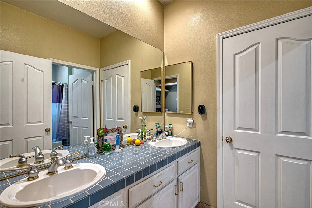 23924 Clarington Drive West Hills, CA 91304 - Photo 27 of 40 a bathroom with a double vanity sink and a mirror