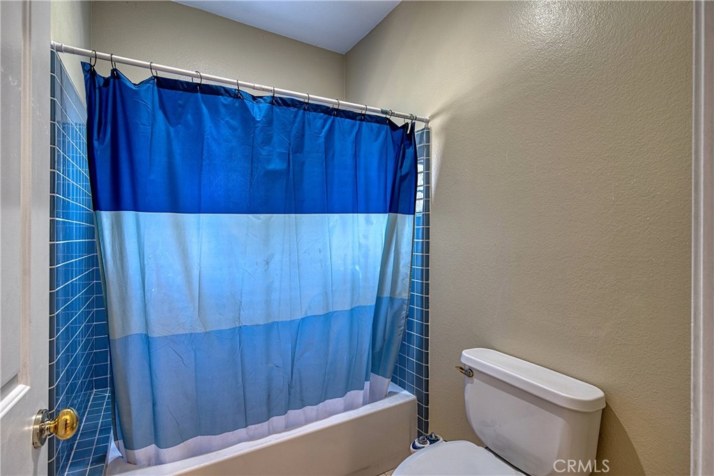 23924 Clarington Drive West Hills, CA 91304 - Photo 28 of 40 a bathroom with a toilet and a shower curtain