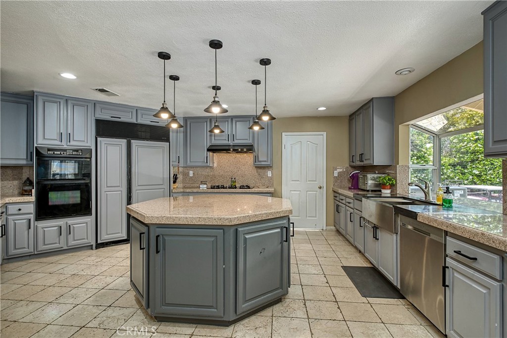 23924 Clarington Drive West Hills, CA 91304 - Photo 8 of 40 a kitchen with stainless steel appliances granite countertop a sink a stove and a refrigerator