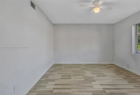 a view of a room with wooden floor and fan