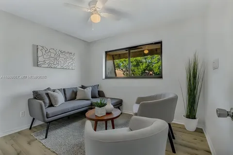 a living room with furniture a window and a potted plant