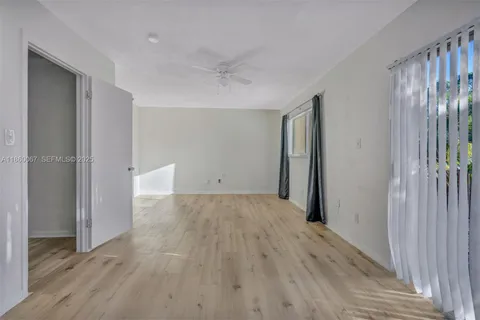 an empty room with wooden floor and a bathroom