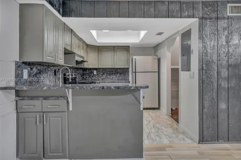 a kitchen with stainless steel appliances granite countertop a refrigerator and a stove