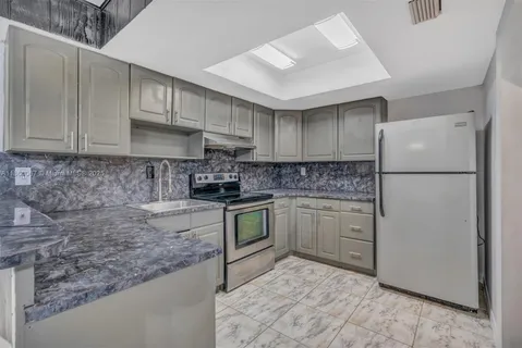 a kitchen with a refrigerator sink and cabinets
