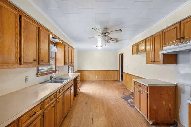 a kitchen with stainless steel appliances granite countertop a sink a stove cabinets and wooden floor