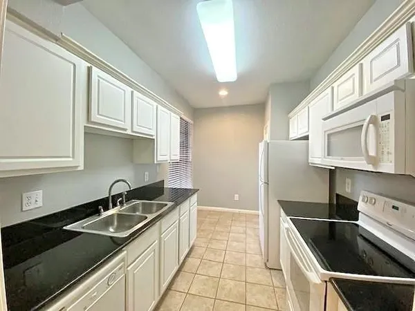 a kitchen that has a sink cabinets counter space and stainless steel appliances