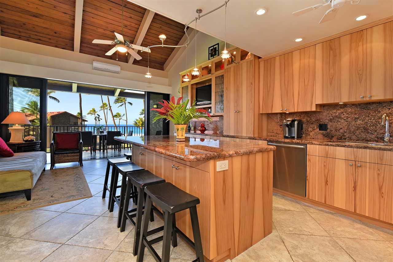 3543 Lower Honoapiilani Road, Unit B405 Lahaina, HI 96761 - Photo 22 of 30 a kitchen with stainless steel appliances kitchen island granite countertop a table chairs and a grill