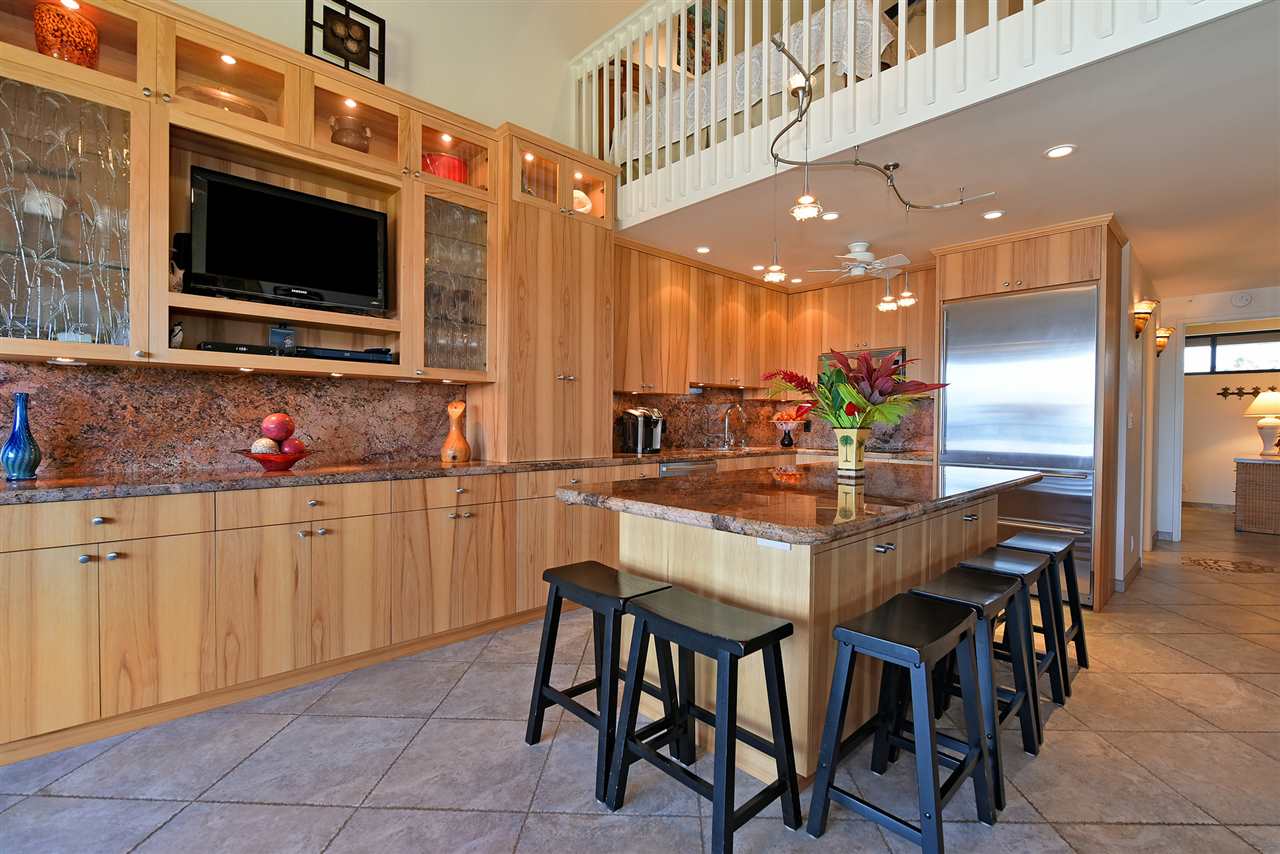 3543 Lower Honoapiilani Road, Unit B405 Lahaina, HI 96761 - Photo 5 of 30 a kitchen with stainless steel appliances kitchen island granite countertop a table and chairs