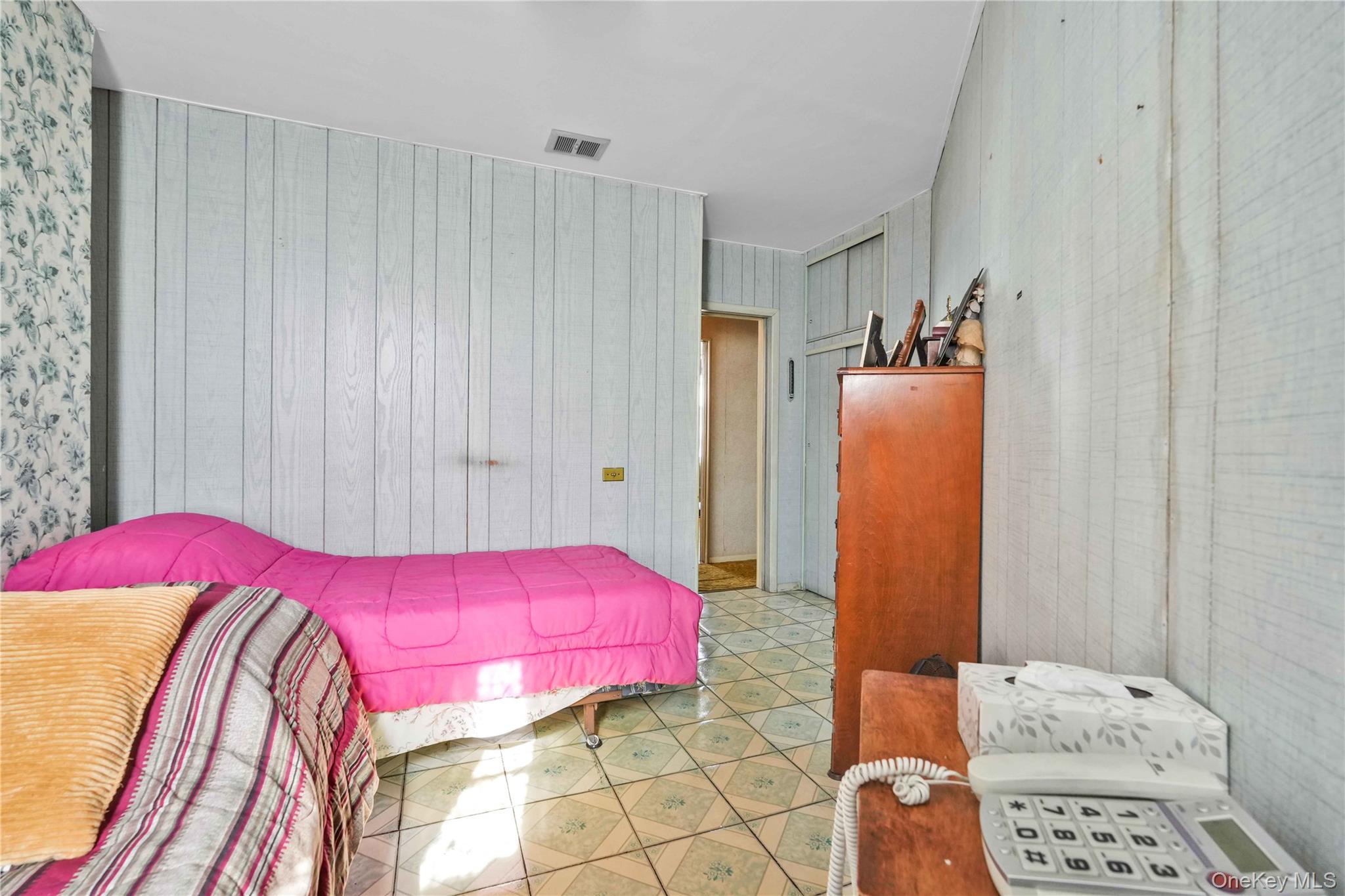 42-01 Newtown Road Queens, NY 11103 - Photo 21 of 27 a bedroom with a bed and a potted plant