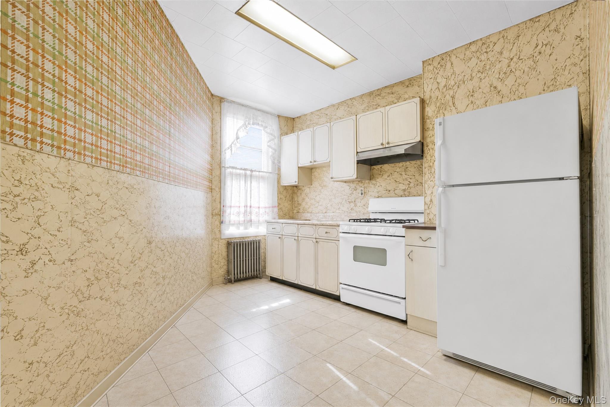 42-01 Newtown Road Queens, NY 11103 - Photo 10 of 27 a kitchen with a stove a sink and a refrigerator