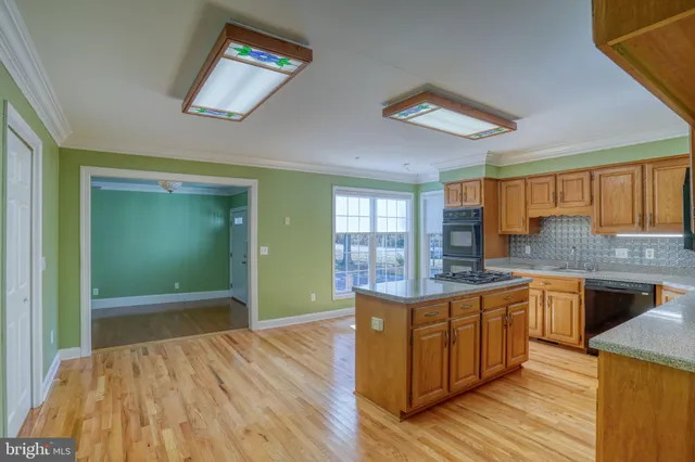 a kitchen with stainless steel appliances granite countertop a stove cabinets and wooden floor