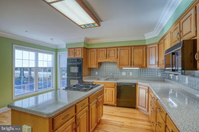 a kitchen with stainless steel appliances granite countertop a sink stove and cabinets