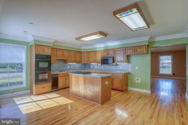 a kitchen with stainless steel appliances granite countertop a refrigerator and a stove top oven