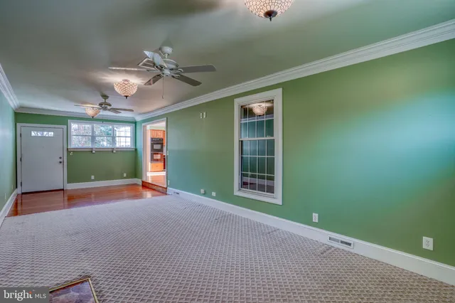 a view of empty room with windows and ceiling fan