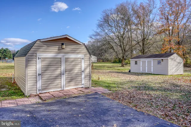 a front view of house with yard and trees in the background