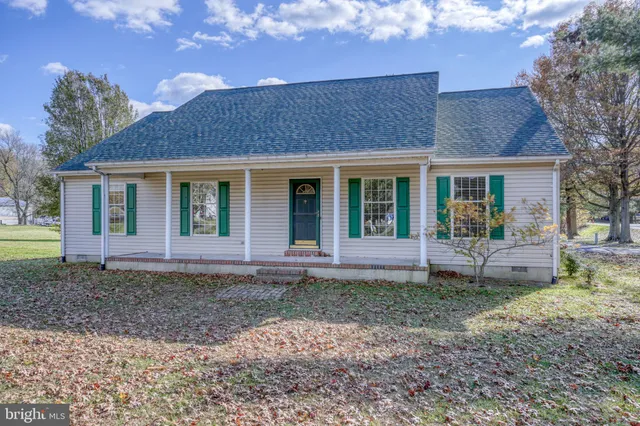 a view of a house with a yard and large tree