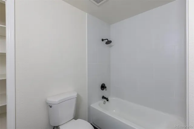 a white bath tub sitting next to a white toilet