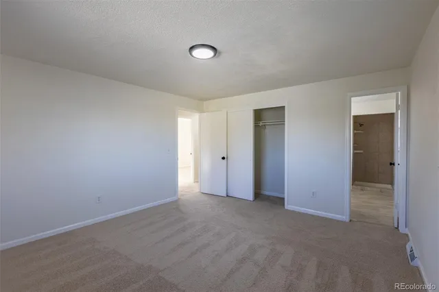 a view of an empty room with closet area