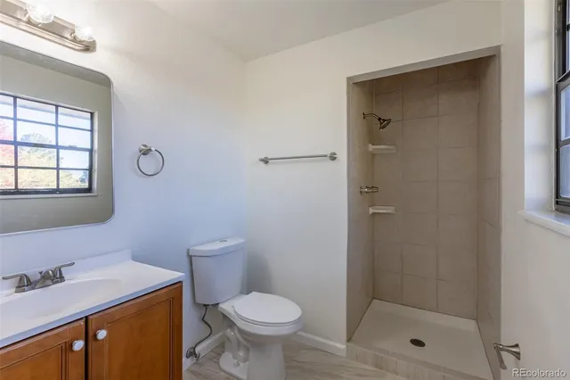 a bathroom with a granite countertop sink toilet and shower