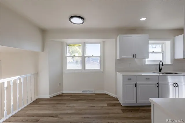 a view of a kitchen with wooden floor and a sink