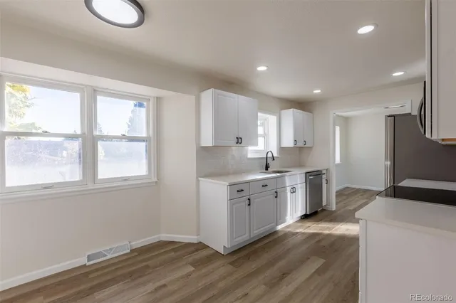 a kitchen with granite countertop cabinets a sink and dishwasher